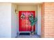 Inviting red double front doors adorned with wreaths, potted plant, and brick accents at 7318 S Mcallister Ave, Tempe, AZ 85283