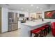 Bright kitchen with stainless steel appliances, white cabinets, and a breakfast bar with red stools at 7318 S Mcallister Ave, Tempe, AZ 85283