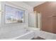 Bright bathroom featuring a soaking tub with a window and a glass enclosed shower at 786 S Catalina St, Gilbert, AZ 85233