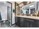 Elegant bathroom with double sinks, dark cabinets, granite counters, and a modern glass shower for a spa-like experience at 8625 E San Alfredo Dr, Scottsdale, AZ 85258