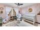 Adorable Bedroom with pink cactus wallpaper, white crib, cozy armchair, and playful decor, creating a warm and inviting space at 8625 E San Alfredo Dr, Scottsdale, AZ 85258
