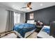 Cozy bedroom featuring a comfortable bed with blue quilt, dark accent wall, and warm lighting for a relaxing retreat at 8625 E San Alfredo Dr, Scottsdale, AZ 85258