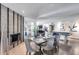 Elegant dining area featuring a modern glass table, velvet chairs, fireplace, and view into adjacent recreation room at 8625 E San Alfredo Dr, Scottsdale, AZ 85258