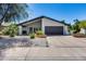 Charming single-story home showcasing desert landscaping, neutral tones, and a black-trimmed roof against a clear blue sky at 8625 E San Alfredo Dr, Scottsdale, AZ 85258