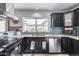 Functional kitchen with dark cabinetry, granite countertops, stainless appliances, and tiled backsplash at 8625 E San Alfredo Dr, Scottsdale, AZ 85258