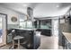 Open kitchen with breakfast bar, black cabinetry, stainless steel appliances, and bright natural light from the outside at 8625 E San Alfredo Dr, Scottsdale, AZ 85258