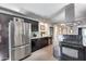 Modern kitchen features stainless steel appliances, dark cabinets, and granite countertops, perfect for cooking and entertaining at 8625 E San Alfredo Dr, Scottsdale, AZ 85258