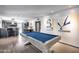 Spacious rec room with a well-lit pool table, modern artwork, and seamless transition to the kitchen area at 8625 E San Alfredo Dr, Scottsdale, AZ 85258
