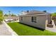 Well-maintained backyard with artificial grass, a cozy seating area, and privacy fencing at 902 E Wahalla Ln, Phoenix, AZ 85024