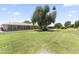 Expansive backyard featuring lush green grass, mature trees, and an inviting screened-in patio, perfect for outdoor living at 9434 W Greenway Rd, Sun City, AZ 85351