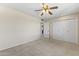 A neutral bedroom features carpeted floor, a ceiling fan, and ample closet space at 9434 W Greenway Rd, Sun City, AZ 85351