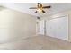 A neutral bedroom features carpeted floor, a ceiling fan, and ample closet space at 9434 W Greenway Rd, Sun City, AZ 85351