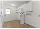 A bright laundry room equipped with storage cabinets, shelving, and a water heater at 9434 W Greenway Rd, Sun City, AZ 85351