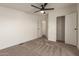 This bedroom features neutral carpet, ceiling fan, and access to closet and bathroom at 9735 W Altadena Dr, Casa Grande, AZ 85194