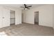 This bedroom features neutral carpet, ceiling fan, and access to closet and bathroom at 9735 W Altadena Dr, Casa Grande, AZ 85194