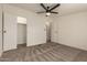 This bedroom features neutral carpet, ceiling fan, and access to closet and bathroom at 9735 W Altadena Dr, Casa Grande, AZ 85194