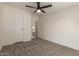 This bedroom features neutral carpet, ceiling fan, and access to closet and bathroom at 9735 W Altadena Dr, Casa Grande, AZ 85194