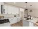 Modern kitchen boasts sleek white cabinetry, stone countertops, and stainless steel appliances at 9735 W Altadena Dr, Casa Grande, AZ 85194