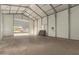 Workshop interior featuring concrete floor, metal walls, and roll-up door at 9735 W Altadena Dr, Casa Grande, AZ 85194