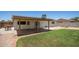 A covered patio overlooks a well-maintained lawn and block fence with a bbq grill at 9825 N 44Th Ave, Glendale, AZ 85302