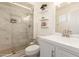 Bathroom featuring a walk-in shower with glass door and floating shelves with decorative accessories at 9825 N 44Th Ave, Glendale, AZ 85302