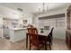 Cozy dining area with a wooden table, stylish chandelier, and bright lighting, adjacent to kitchen at 9825 N 44Th Ave, Glendale, AZ 85302