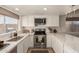 Bright kitchen featuring white cabinets, stainless steel appliances, sleek countertops, and a large window at 9825 N 44Th Ave, Glendale, AZ 85302