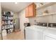 Laundry room with full size washer and dryer and shelving for storage and detergent at 9825 N 44Th Ave, Glendale, AZ 85302
