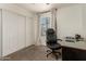 Office space with a desk, chair, and carpeted floors, featuring a large closet and window at 9825 N 44Th Ave, Glendale, AZ 85302