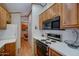Well-lit kitchen with white countertops, wood cabinets, and modern appliances at 111 S Greenfield Rd # 405, Mesa, AZ 85206