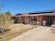 Ranch-style home with a red roof, solar panels, a covered parking area, and a chain link fence at 1116 E Almeria Rd, Phoenix, AZ 85006