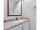 Bathroom vanity with granite countertop, white cabinetry, and a decorative mirror at 11217 E Laurel Ln, Scottsdale, AZ 85259