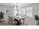 An elegant dining room is illuminated by a modern chandelier and features an eye-catching centerpiece with plantation shutters at 11217 E Laurel Ln, Scottsdale, AZ 85259