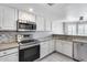 Bright kitchen showcasing modern stainless steel appliances, granite countertops, and white cabinetry at 11217 E Laurel Ln, Scottsdale, AZ 85259
