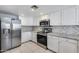 Well-lit kitchen featuring stainless steel appliances, white cabinetry, mosaic tile backsplash, and granite countertops at 11217 E Laurel Ln, Scottsdale, AZ 85259