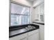 Clean laundry room featuring black counters, white cabinets, a utility sink, and a bright window at 11217 E Laurel Ln, Scottsdale, AZ 85259