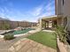 Beautiful backyard with a custom pool, lush landscaping, covered patio, and outdoor fireplace at 11534 E Downing St, Mesa, AZ 85207