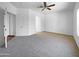 Bright bedroom with neutral carpet, ceiling fan, and an archway leading to the bathroom at 11534 E Downing St, Mesa, AZ 85207