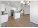 Spacious kitchen features white cabinetry, stainless steel appliances, and an island with views to the main living space at 11534 E Downing St, Mesa, AZ 85207