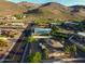 Aerial view of a neighborhood with desert landscaping, homes, street and mountains in the background at 13034 N 8Th Ave, Phoenix, AZ 85029