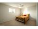 Bedroom with neutral carpet, ceiling fan with light, and simple black bed with colorful cushions at 13034 N 8Th Ave, Phoenix, AZ 85029