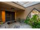 Covered front patio area with tiled floor and a view into a green courtyard space at 13034 N 8Th Ave, Phoenix, AZ 85029