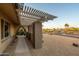 Home's front entry featuring a shaded pergola, drought-tolerant landscaping, and an arched entrance at 13034 N 8Th Ave, Phoenix, AZ 85029