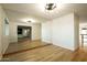 Bright living room with hardwood floors and large mirror reflecting the open floor plan at 13034 N 8Th Ave, Phoenix, AZ 85029