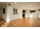 Open living room with hardwood floors, a pass-through to the kitchen, and bright lighting at 13034 N 8Th Ave, Phoenix, AZ 85029