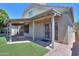 Backyard view showcasing the home's stucco exterior, covered patio, and artificial grass at 1417 E Marshall Ave, Phoenix, AZ 85014