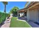 Backyard view featuring a covered patio, artificial grass, stone water feature, and lush landscaping at 1417 E Marshall Ave, Phoenix, AZ 85014
