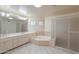 Well-lit bathroom showcasing a large soaking tub, a walk-in shower, and dual vanities at 1417 E Marshall Ave, Phoenix, AZ 85014