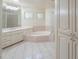 Bright Primary bathroom with double vanity sinks, soaking tub, tiled floors, and separate shower at 1417 E Marshall Ave, Phoenix, AZ 85014
