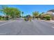Community entrance with black iron gates, lush trees, and meticulously maintained landscaping under a clear sky at 1417 E Marshall Ave, Phoenix, AZ 85014